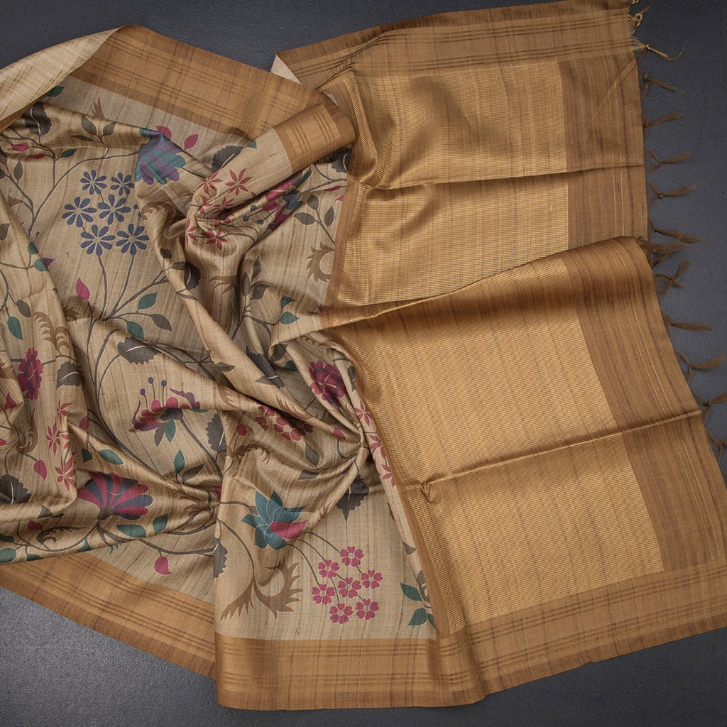 Golden brown raw silk saree with floral print and intricate zari border by Shriyara Life, showcasing elegant traditional craftsmanship.