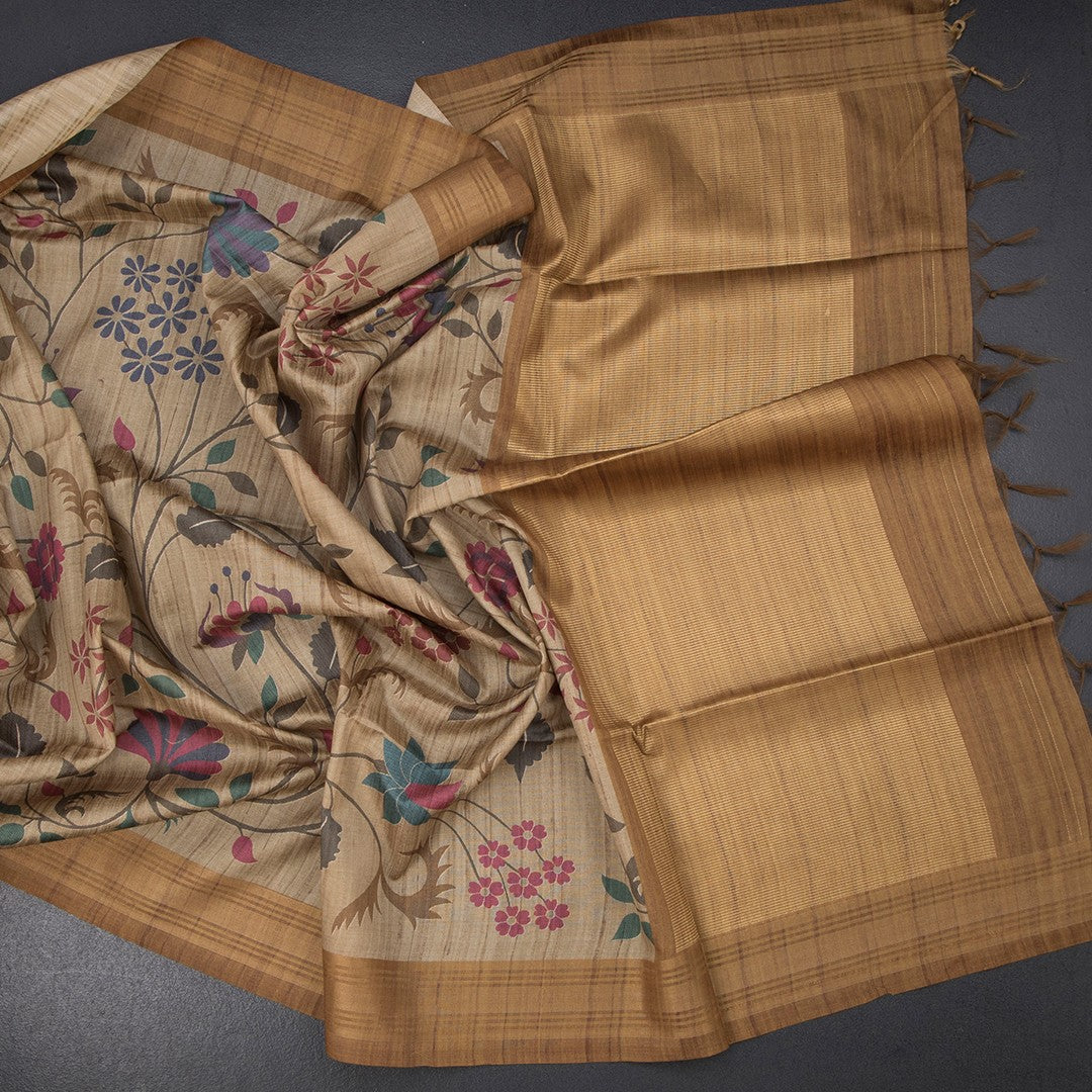 Golden brown raw silk saree with floral print and intricate zari border by Shriyara Life, showcasing elegant traditional craftsmanship.