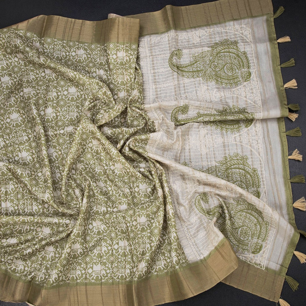 Green raw silk saree with printed design and zari border from Shriyara Life, featuring intricate weaving and vibrant traditional patterns.